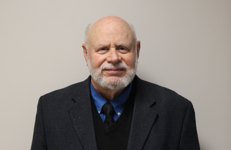 Headshot of a smiling older man.